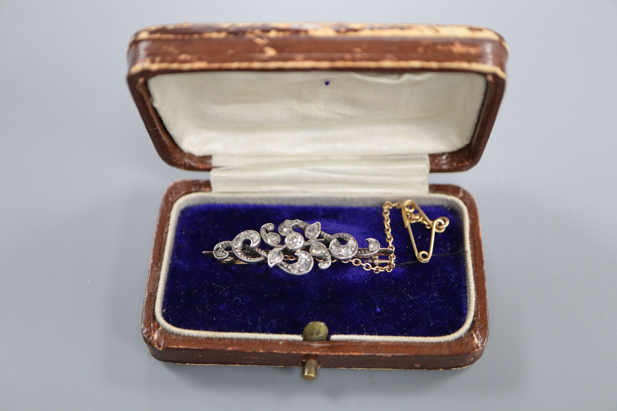 A Victorian yellow and white metal, round and rose cut diamond set scrolling bar brooch, 36mm, gross 3.8 grams.